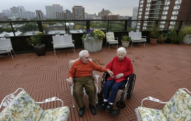 In this Sept. 18, 2013, photo, Holocaust survivors, Joe Chaba, 85, and his wife, Helen, 89, sit together on the rooftop at the retirement community called Selfhelp Home, on the North Side of Chicago. In his later years, Joe says he thinks more about his days in a camp at age 10, constantly staring death in the face _ sometimes unloading piles of bodies from trucks _ but never contemplating it for himself. Life was a day-to-day proposition. (AP Photo/M. Spencer Green)