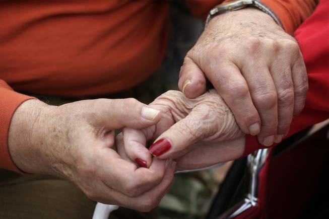 In this Sept. 18, 2013 photo, Holocaust survivors Joe Chaba holds hand with his wife, Helen Chaba, 89, at the retirement community called Selfhelp Home, on the North Side of Chicago. Married 55 years, they're inseparable, whispering to one another, sharing meals. Helen, 89, has dementia; they have 24-hour nursing care. (AP Photo/M. Spencer Green)