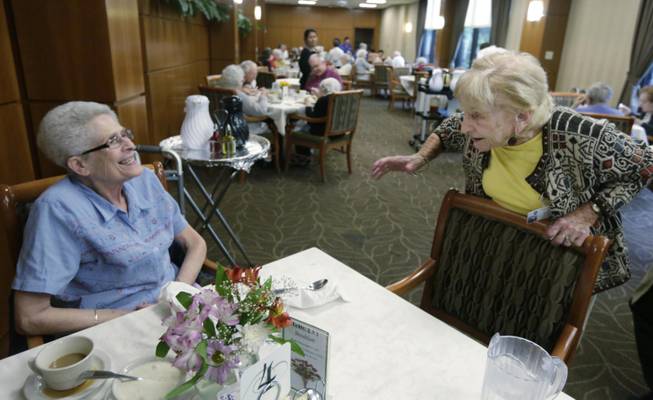FILE - In this July 30, 2013 file photo, Holocaust survivor, 92-year-old Edith Stern, right, talks with a new resident in the cafeteria at the retirement community called Selfhelp Home, on the North Side of Chicago. Stern moved to Chicago in 1965 and joined the staff of Selfhelp, developing an instant rapport with the other refugees. "The reason I wanted to work there was I could never do anything for my parents because they were killed," she says. "These people could have been my parents ... I loved them and they loved me." (AP Photo/M. Spencer Green, File)