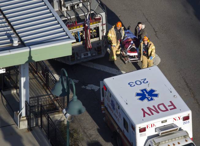 A person is evacuated from the scene of the derailment of a Metro-North passenger train in the Bronx borough of New York Sunday, Dec. 1, 2013. The Fire Department of New York says there are "multiple injuries" in the train derailment, and 130 firefighters are on the scene. Metropolitan Transportation Authority police say the train derailed near the Spuyten Duyvil station.