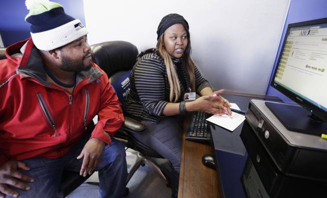 In this Nov. 8, 2013, photo, enrollment counselor Kenya Williams helps Jerome Davis Jr. 36, sign up for Medicaid at the Westside Health Authority in Chicago. For Davis, an unemployed construction worker, expansion of Medicaid means he'll be able to see a doctor without fear of medical bills he can't pay.