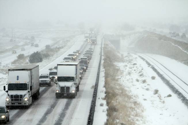 Traffics is backed up on highway I-25 after a winter storm system swept through Thursday, Dec. 5, 2013, in La Bajada, N.M. The system swept dumped up to 6 inches of snow across the state and causing highway headaches, school closures and delays.