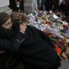 Photo: Two women embrace after they placed their floral t Photo: Two women embrace after they placed their floral t