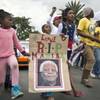 Photo: A young girl with a placard showing the face of Ne Photo: A young girl with a placard showing the face of Ne
