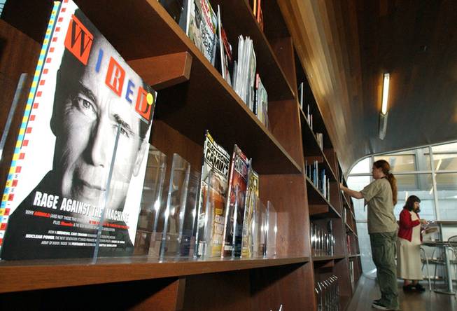 The new racks of magazines rising from dark hardwood flooring through to the ceiling help give the feel of a large, modern bookstore to the newly renovated first floor of the Carnegie Library of Pittsburgh's Oakland branch as librarians stock the shelves on Wednesdy, Sept. 15, 2004.