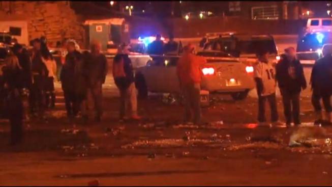 In this image from television provided courtesy of KMGH-TheDenverChannel.Com, people mill around the area where at least three people were stabbed Thursday, Dec. 12, 2013, in a parking area at at Sports Authority Stadium Field at Mile High after the Denver Broncos' game.