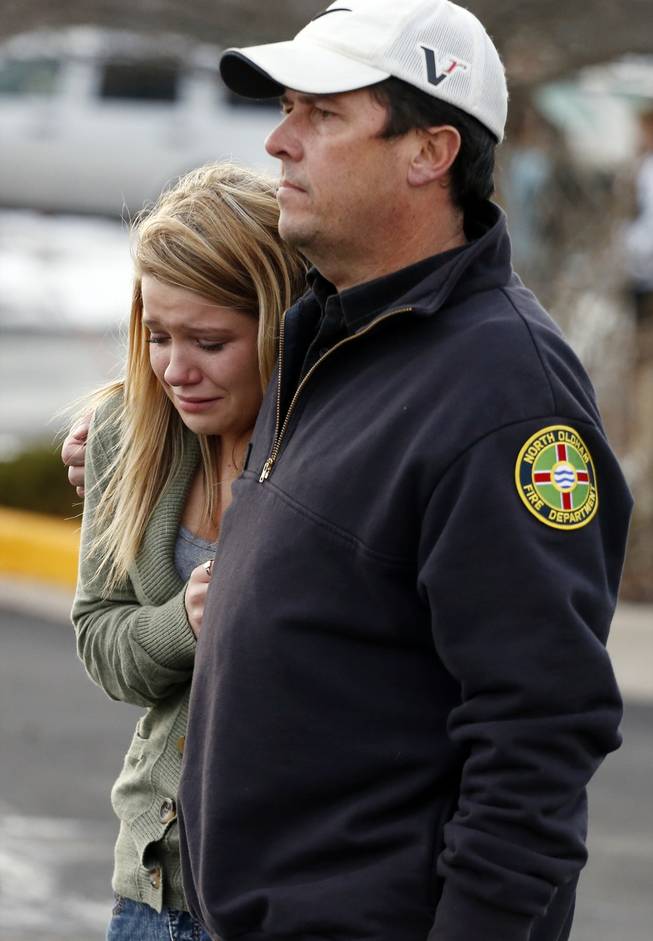 A father picks up his daughter at a church where students from nearby Arapahoe High School were evacuated to after a shooting on the Centennial, Colo., campus Friday, Dec. 13, 2013. Arapahoe County Sheriff Grayson Robinson said the shooter shot two others at the school, before apparently killing himself.