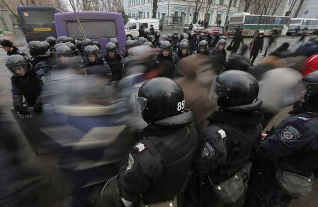 Pro-European Union activists pass through a police line as they march against the government in Kiev, Ukraine, Tuesday, Dec. 17, 2013. Weeks of angry pro-European Union protests as well as Western pressure have forced Yanukoyvch to make some concessions to the opposition. Last week Yanukovych called for an amnesty for some of the activists detained.