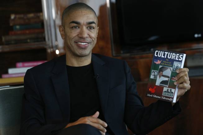 Mark Obama Ndesanjo, U.S. President Barack Obama's half-brother, holds his self-published book "Cultures: My Odyssey of Self-Discovery" during an interview in Hong Kong. President Barack Obama’s half-brother is publishing the autobiography that details the domestic abuse that served as the theme for his earlier semiautobiographical novel, which featured an abusive parent patterned on their late father.