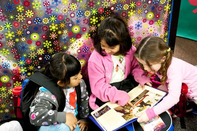 Estrella Vasquez, from left, Akemi Hernandez and Camryn Fedderson look at a book about Siegfried and Roy's lives they received in their backpacks provided by Siegfried and Roy during the holiday party at the Boys and Girls Club at 2801 E. Stewart Avenue in Las Vegas December 20, 2013.