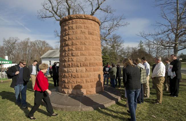 Relatives and friends of the victims of the bombing of Pan Am Flight 103 gather around the memorial cairn at Arlington National Cemetery, in Arlington, Va., Saturday, Dec. 21, 2013, during a memorial service to mark the 25th anniversary of the bombing of the Pan Am Flight 103 that crashed over Lockerbie, Scotland.