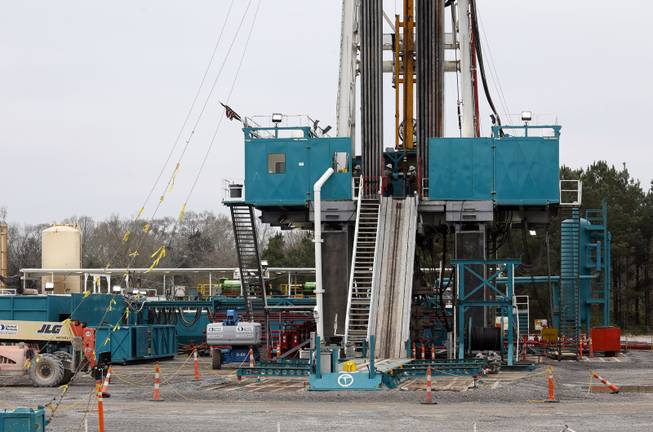In this Dec. 23, 2013 photograph, Encana Corp., contractors work on a drilling rig in Amite County Supervisor Max Lawson's back pasture in Gillsburg, Miss. After a little more than two-years waiting to see if additional oil work would be done on a gravel pad, Lawson recalls the convoy of about 200 trucks bring the drilling rig and other gear to his property in late 2013.