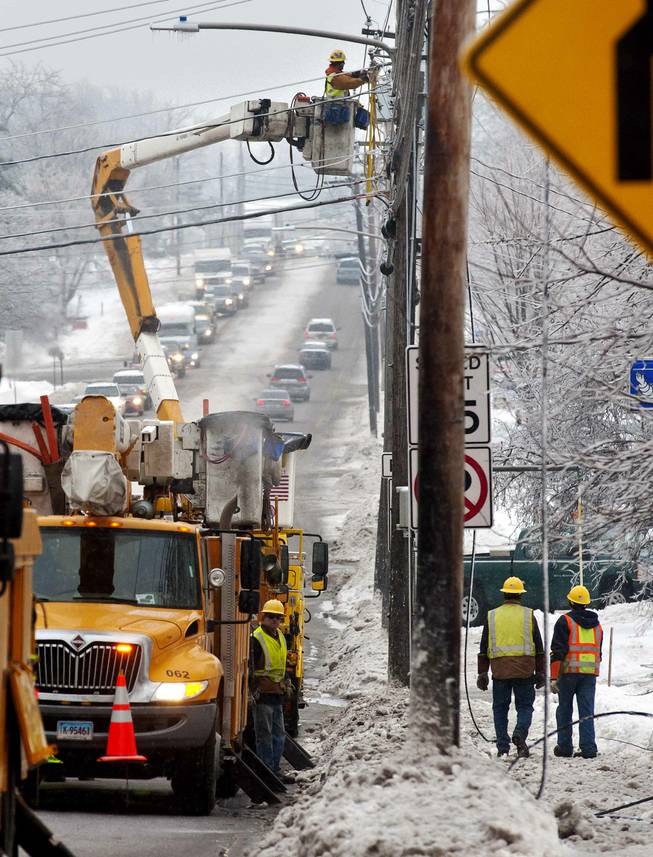 Utility crews respond to a downed power line at the intersection of Dorset Street and Kennedy Drive in South Burlington, Vt., on Monday, Dec. 23, 2013. From Michigan to Maine, hundreds of thousands remain without power days after a massive ice storm _ which one utility called the largest Christmas-week storm in its history _ blacked out homes and businesses in the Great Lakes and Northeast. (AP Photo/Burlington Free Press, Glenn Russell)