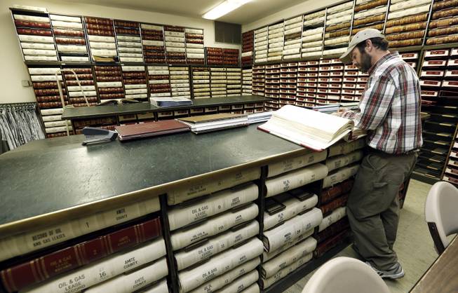 In this Dec. 23, 2013 photograph, attorney Graham Whitehead of Hattiesburg, searches records at the Amite County courthouse in Liberty, Miss. Whitehead took advantage of a slow period before the holidays to search for mineral rights and royalty transfers. According to Chancery Clerk Ronnie Taylor, the records room has several leasing agents doing research on a daily basis.