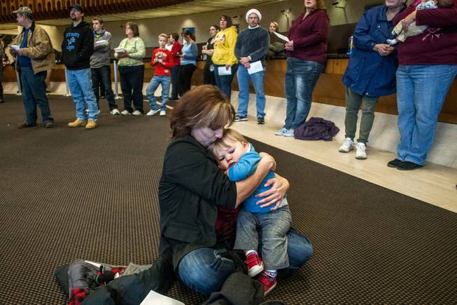 Carla Coulter, 46, of Clio, holds her 1-year-old grandson Connor Hergert closely as she gives him a kiss on the forehead while listening to the FirstMerit Bank Mixed Chorus sing "Silent Night" along with about 100 spectators during the 76th Annual Holliday Sing on Tuesday, Dec. 24, 2013 at FirstMerit Bank in downtown Flint, Mich. "We don't have power. We're warming up, and I just feel so very blessed to have my family," Coulter said. "I don't need anything else." (AP Photo/The Flint Journal, Jake May) LOCAL TV OUT; LOCAL INTERNET OUT