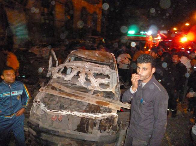 Egyptians gather after a powerful explosion believed to be caused by a car bomb rocked a police headquarters in the Nile Delta city of Mansoura, 110 kilometers (70 miles) north of Cairo, early on Tuesday, killing more than a dozen people and wounding dozens, according to the state news agency and a security official. No one immediately claimed responsibility for the bombing, which came a day after an al-Qaida-inspired group called on police and army personnel to desert or face death at the hands of its fighters.