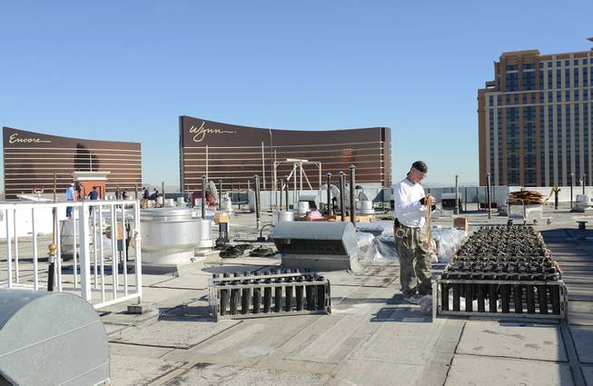 In this photo provided by the Las Vegas News Bureau, a technician from Fireworks by Grucci makes preparations atop of the Treasure Island hotel for the Las Vegas New Years Eve pyrotechnic extravaganza, Monday, Dec. 30, 2013 in Las Vegas, Nev. The program will launch more than 80,000 effects from the MGM Grand, Aria, Planet Hollywood, Caesars Palace, Treasure Island, The Venetian and Stratosphere. (Photo/Las Vegas News Bureau, Darrin Bush)