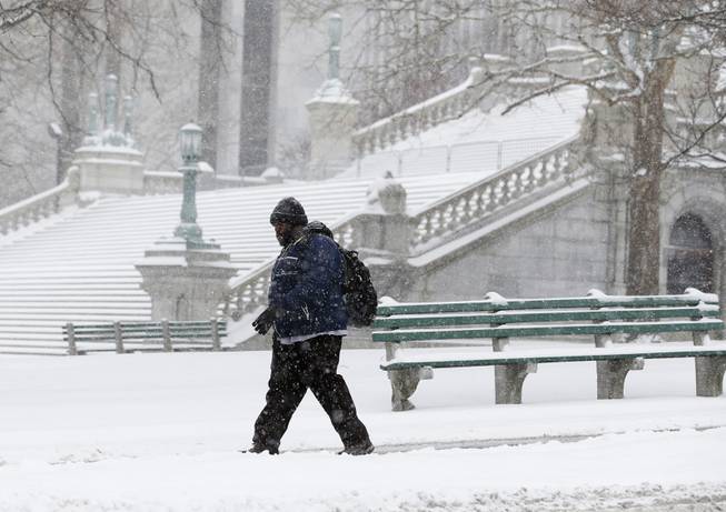 A pedestrian walks through the snow outside the state Capitol on Thursday, Jan. 2, 2014, in Albany, N.Y. Up to 5 inches of snow have fallen in eastern New York early Thursday, but the National Weather Service said some areas from Buffalo to Albany could get up to 12 inches by the time the storm subsides on Friday.