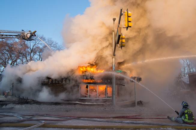 Ann Arbor firefighters battle a fire at Happy's Pizza in Ann Arbor, Mich., on Tuesday, Jan. 7, 2014. Firefighters worked for several hours in temperatures that dipped to 15 degrees below zero to extinguish a blaze at the pizza shop. No injuries were reported following the fire.