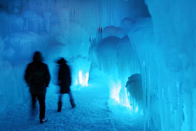 In this photo taken Wednesday Jan. 8, 2014 patrons tour an ice castle at the base of the Loon Mountain ski resort in Lincoln, N.H. The ice castle begins to grow in the fall when the weather gets below freezing and thousands of icicles are made and harvested then placed around sprinkler heads and sprayed with water. The castle will continue to grow as long as the temperatures stay below freezing.