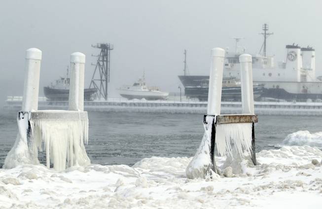 Ice forms on parts of a dock on West Grand Traverse Bay near the Great Lakes Maritime Academy in Traverse City, Mich. It may be hard to think of this week's deep freeze as anything but miserable. But in the realm of nature, there are silver linings: Heavy ice cover may help raise low water in the Great Lakes and protect shorelines and wetlands from erosion.