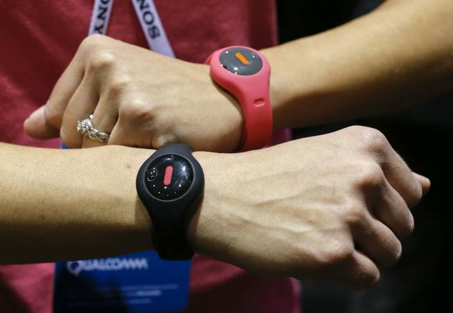 Fitbug Orb activity trackers are worn by an exhibit representative during the International Consumer Electronics Show on Sunday, Jan. 5, 2014, in Las Vegas. Fitbug has introduced KiK Plans, which are the first ever customized exercise and diet programs that work with Fitbug activity trackers to provide the guidance needed to reach health and fitness goals for important occasions.