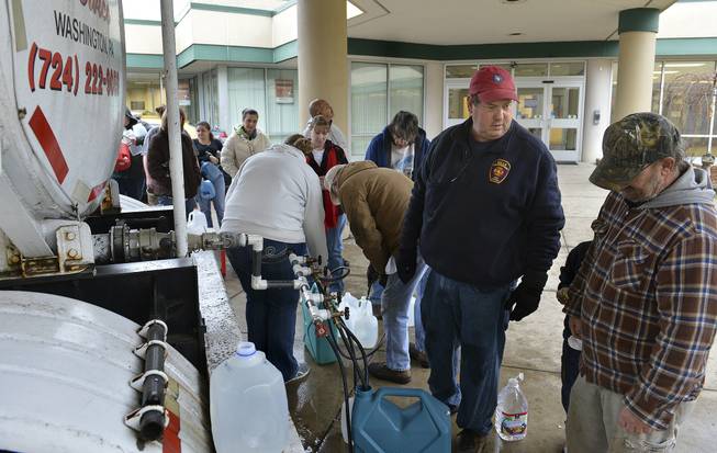 David Fletcher, center, a member of the Belle Fire Department, took off a day of work at his accounting job for the state so he could help distribute water at Riverside High School in Charleston, W.Va., after a chemical spill in the Elk River in Charleston shut down much of the city and surrounding counties, Friday Jan 10, 2014. He said that earlier he dropped off some water for some of his elderly neighbors.