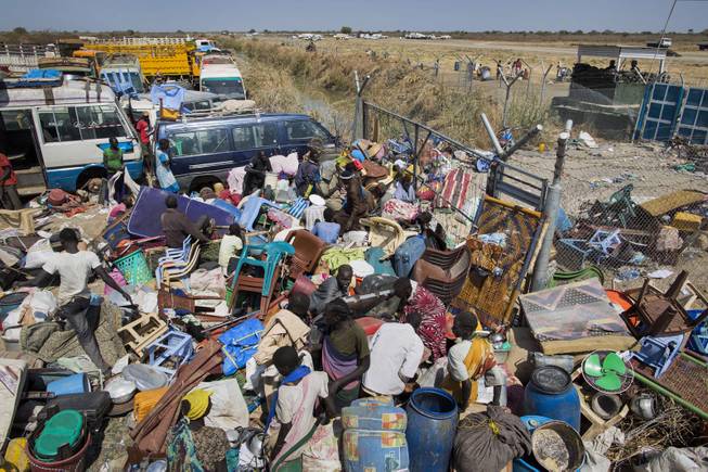 Civilians who fled the recent fighting stack their belongings up outside the gate of the United Nations Mission in South Sudan (UNMISS) compound, hoping to benefit from their protection, after government forces on Friday retook from rebel forces the provincial capital of Bentiu, in Unity State, South Sudan, Sunday, Jan 12, 2014.