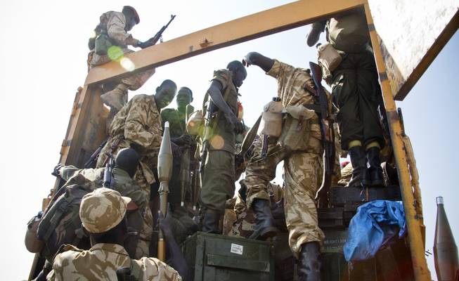 Some of hundreds of government soldiers board various vehicles, as they prepare to travel towards the frontline, to reinforce government forces already fighting rebel forces near the town of Bor, as they prepare to leave from the outskirts of Juba, South Sudan, Monday, Jan. 13, 2014.