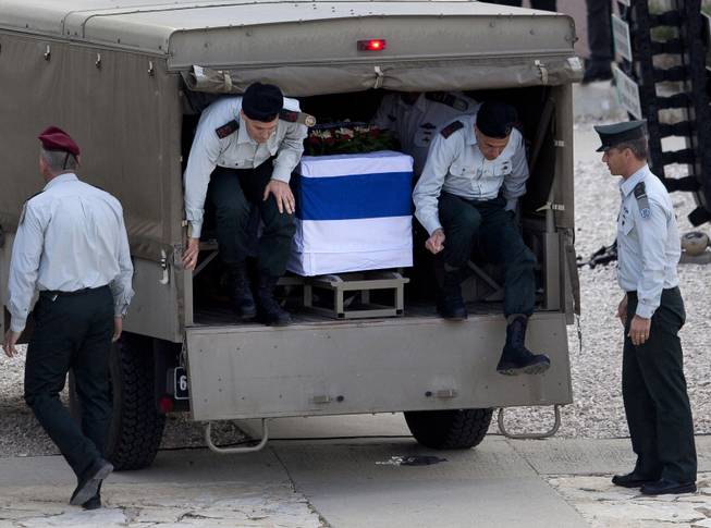 Israeli generals jump off a military vehicle with the coffin of former Israeli Prime Minister Ariel Sharon as it stops at the Armored Corps memorial for fallen soldiers in Latrun, site of a bloody battle where Sharon was wounded during Israel's war of independence in 1948, for a brief ceremony before continuing south, near Jerusalem, Israel, Monday, Jan. 13, 2014.