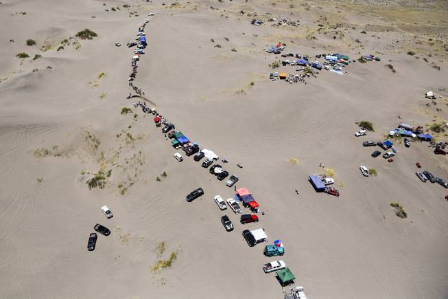 Spectators camp on the dunes to watch the second stage of the Dakar Rally between the cities of San Luis and San Rafael in San Rafael, Argentina, Monday, Jan. 6, 2014. This is the sixth consecutive year the race has been run in South America, and the first time Bolivia has been on the route.