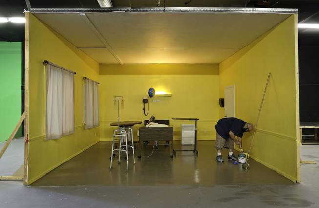 Studio owner and porn film director Lee Roy Myers prepares paint while working on a hospital room set at his studio, Mission Control Studios, Wednesday, Jan. 15, 2014, in Las Vegas. With increasing costs of doing business and a Los Angeles law requiring male actors to wear condoms, Myers moved his studio to Las Vegas last Spring and is part of the new boom in X-rated production in Sin City.