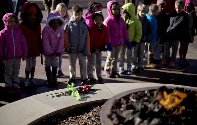 Roses sit in front of the eternal flame at the gravesite of Rev. Martin Luther King Jr., as kindergarten students with the Charles R. Drew Charter School pay a visit, Friday, Jan. 17, 2014, in Atlanta. The national Dr. Martin Luther King Jr. federal holiday this year is Monday, Jan. 20, five days after the civil rights leader would have turned 85-years-old.