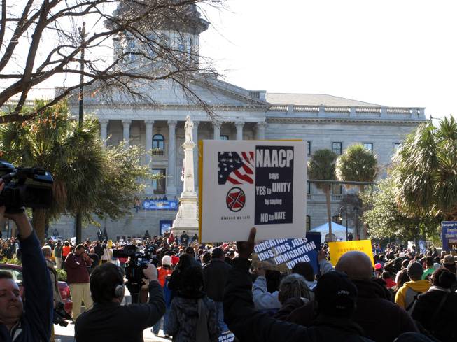 Marchers make their way to the South Carolina Statehouse during the King Day rally on Monday, Jan. 20, 2014, in Columbia, S.C. NAACP President William Barber told the crowd of a few thousand people that what conservatives leaders have done to the country is mighty low, but he thinks they are ready to find higher ground.