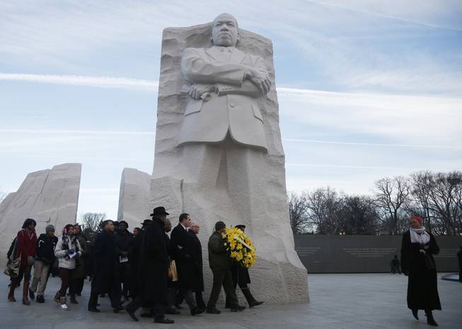 Washington D.C. Mayor Vincent Gray, fourth from right, takes part in an annual wreath laying ceremony at the Martin Luther King Jr. Memorial in Washington, Monday, Jan. 20, 2014. The nation paused to remember Martin Luther King Jr. Monday with parades, marches and service projects. King was born Jan. 15, 1929, and the federal holiday is the third Monday in January.