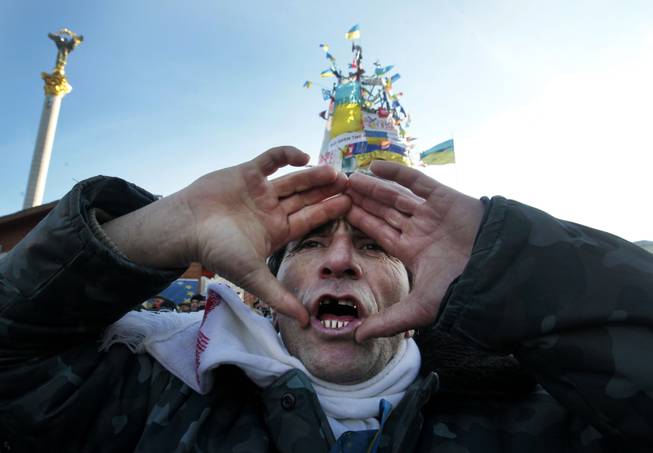 A pro-European Union activist shouts a slogan during a rally in Independence Square in Kiev, Ukraine, Sunday, Dec. 22, 2013. Protesters in Kiev are demanding President Viktor Yanukovych's resignation over his decision to ditch a pact with the European Union in favor of closer ties with Russia.