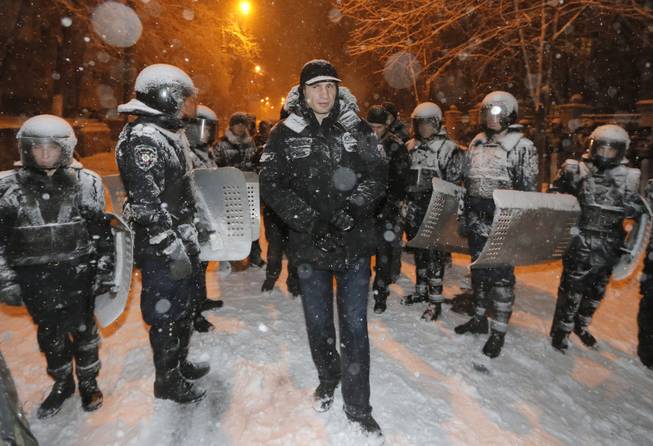Ukrainian lawmaker and chairman of the opposition party Udar (Punch), WBC heavyweight boxing champion Vitali Klitschko surrounded by police trying to stop the possible collisions between police and Pro-European Union activists in Kiev, Ukraine, Monday, Dec. 9, 2013. Hundreds of police in full riot gear on Monday flooded the center of Kiev key sites of mass anti-government protests that have gripped the capital for weeks, raising fears of a crackdown.