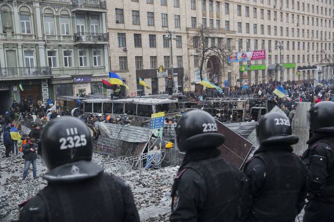 Police guard the way to the Government buildings in central Kiev, Ukraine, Tuesday, Jan. 21, 2014. Anti-government protesters have held their ground through a night of violent street clashes in the Ukrainian capital, despite police moving in to dismantle barricades erected in a street leading to government offices. Police attempted to move in on the protest camp early Tuesday, but faced fierce resistance from demonstrators who tossed fire bombs and stones in their direction.