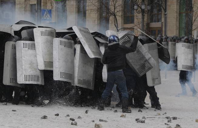 A protester attacks police in central Kiev, Ukraine, Wednesday, Jan. 22, 2014. Police in Ukraineis capital on Wednesday tore down protester barricades and chased demonstrators away from the site of violent clashes, hours after two protesters died after being shot, the first violent deaths in protests that are likely to drastically escalate the political crisis that has gripped Ukraine since late November.