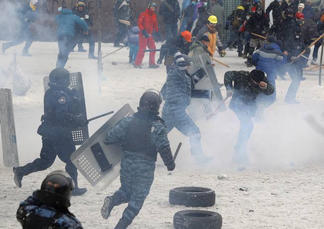 A police officer beats a protester during clashes in central Kiev, Ukraine, Wednesday, Jan. 22, 2014. Police in Ukraineis capital on Wednesday tore down protester barricades and chased demonstrators away from the site of violent clashes, hours after two protesters died after being shot, the first violent deaths in protests that are likely to drastically escalate the political crisis that has gripped Ukraine since late November.