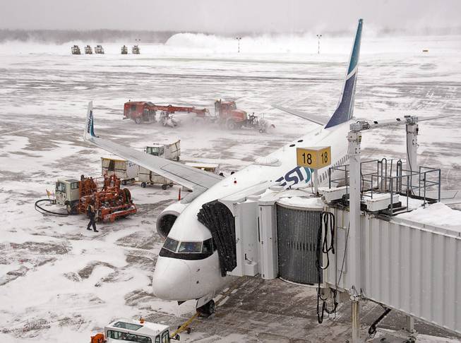 Crews clear the runways at Halifax Stanfield International Airport in Halifax on Wednesday, Jan. 22, 2014. A winter storm system moving along the eastern seaboard continues to intensify across areas of Atlantic Canada cancelling schools and leading to flight delays and cancellations at airports.