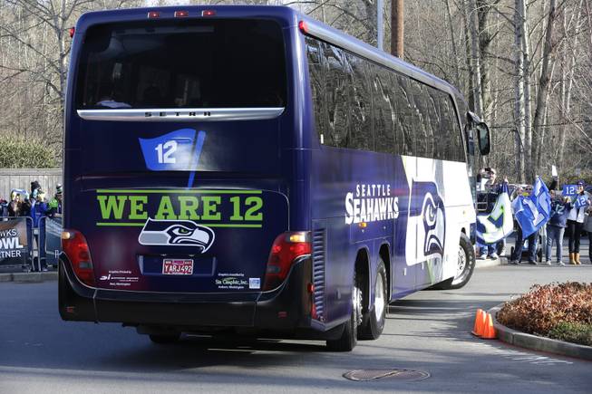 Fans cheer as buses carrying Seattle Seahawks players and coaches leave team headquarters in Renton, Wash., Sunday, Jan. 26, 2014. The team took the buses to the airport for their flight to play the Denver Broncos in the NFL Super Bowl XLVIII football game in East Rutherford, N.J.