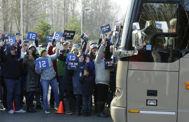Fans cheer as buses carrying Seattle Seahawks players and coaches leave team headquarters in Renton, Wash., Sunday, Jan. 26, 2014. The Seahawks were heading to the airport for their flight to play the Denver Broncos in the NFL Super Bowl XLVIII football game in East Rutherford, N.J.