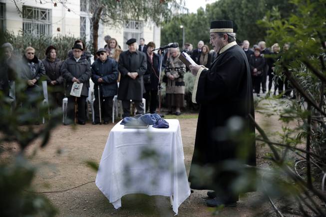 A Rabbi reads a prayer in front of Holocaust victims during a ceremony outside Beit Shalom Synagogue in central Athens, Monday, Jan. 27, 2014. During World War II over 67,000 Greek Jews, 87% of the Jewish population of Greece were victims, statistically the highest percentage of Jewish loss of any officially occupied country.