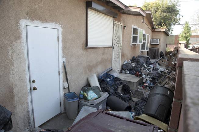 Trash is shown stacked against the home of William Buchman Wednesday Jan. 29, 2014 in Santa Ana, Calif. Buchman has been arrested for investigation of neglect in the care of animals, after authorities found at least 300 living and dead pythons in plastic bins inside Buchman's stench-filled suburban home.