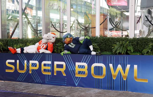 Blitz, right, the Seattle Seahawks mascot, is sits with Miles, left, the Denver Broncos mascot, Friday, Jan. 31, 2014 on top of a Super Bowl sign during a live broadcast of Good Morning America at Times Square in New York. The Seattle Seahawks will play the Broncos Sunday in the NFL Super Bowl XLVIII football game in East Rutherford, N.J.