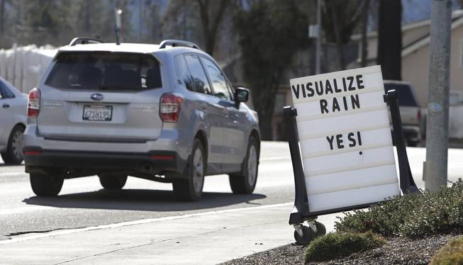 In this photo taken Tuesday, Feb. 4, 2014, a sign outside a market in Willits, Calif., reminds passerby's about about the short water supply facing area residents. In the midst of a historic drought and area reservoirs holding less than a 100-day supply of water, Willits city leaders have banned lawn watering, car washing and mandated all residents to cut water use.