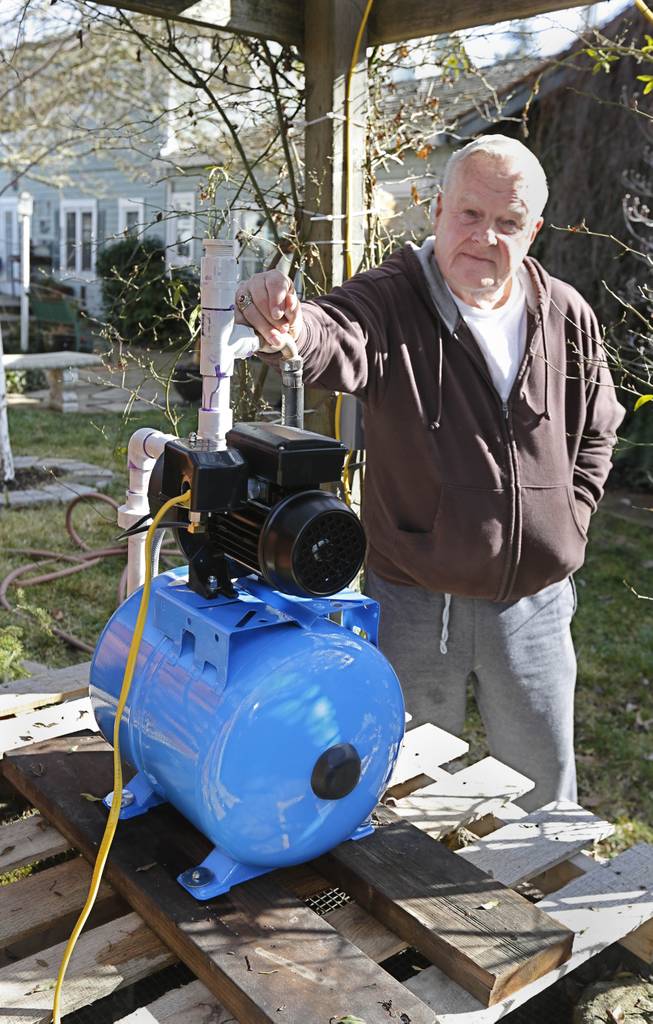 In this photo taken Tuesday, Feb. 4, 2014, Charles Davison, a retired high school principal, installed a pump on a unused well on to help supplement his household water supply at his home in Willits, Calif. In the midst of an historic drought and area reservoirs holding less than a 100-day supply of water, Willits city leaders have banned lawn watering, car washing and have asked restaurants to serve water only upon request.