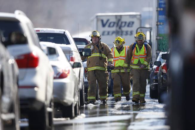 Firefighters check in on motorist in vehicles are piled up in an accident, Friday, Feb. 14, 2014, in Bensalem, Pa. Traffic accidents involving multiple tractor trailers and dozens of cars have completely blocked one side of the Pennsylvania Turnpike outside Philadelphia and caused some injuries.