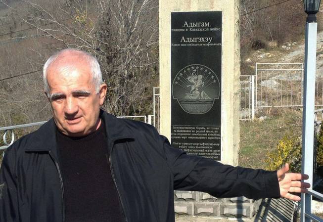Khalid Tlif, a resident of the Bolshoi Kichmai village near Sochi, Russia, points toward a monument to his Circassian ancestors killed by czarist armies in the Caucasus wars of the 19th century on Saturday, Feb. 15, 2014. Circassians, a Muslim ethnic group native to these lands that Putin chose for his Olympic project, were massacred and exiled by czarist troops, persecuted under Stalin and largely ignored in the run-up to the Sochi Games.